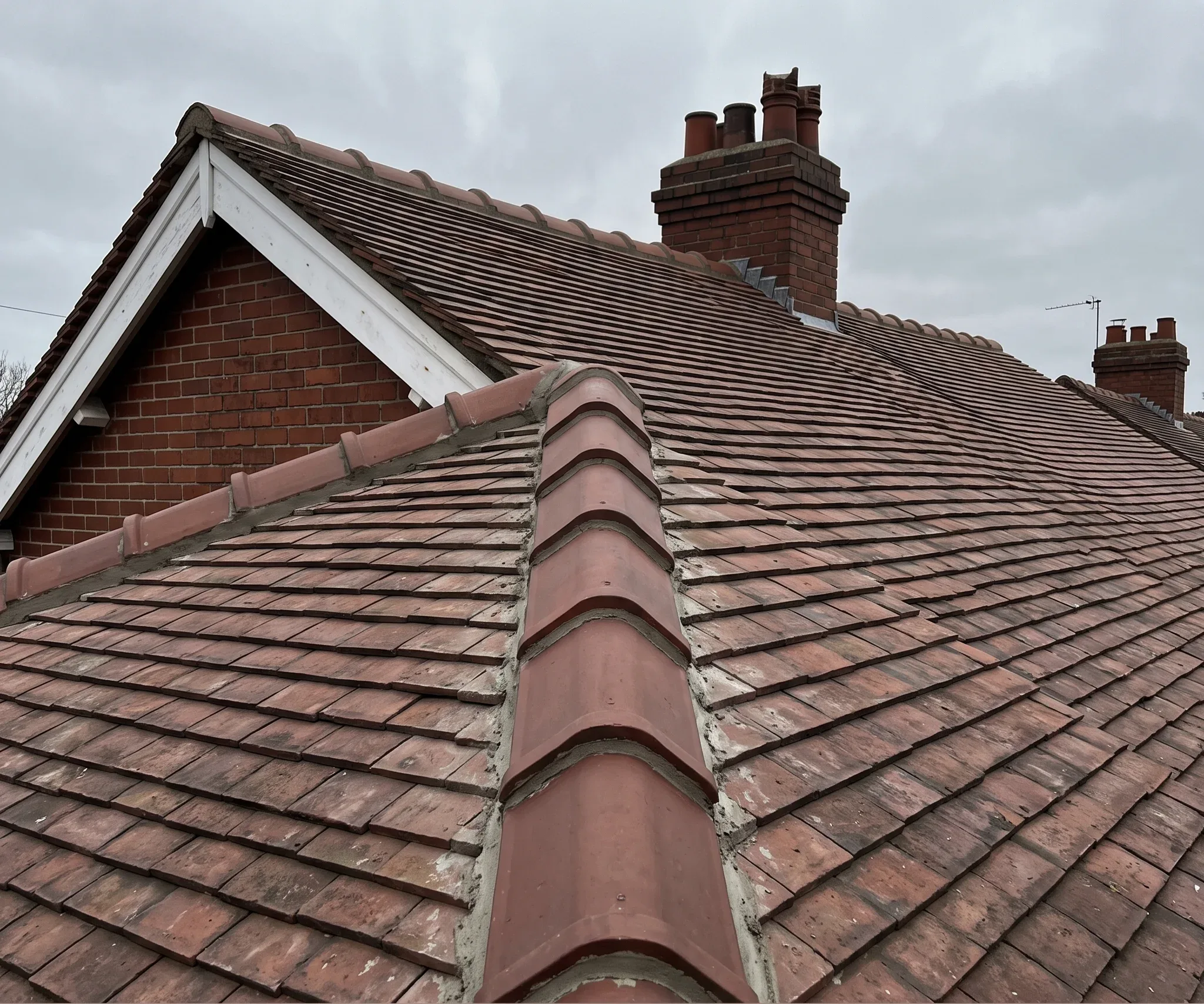 Re-bedded clay pantile ridge running to a brick verge on a 1930s semi